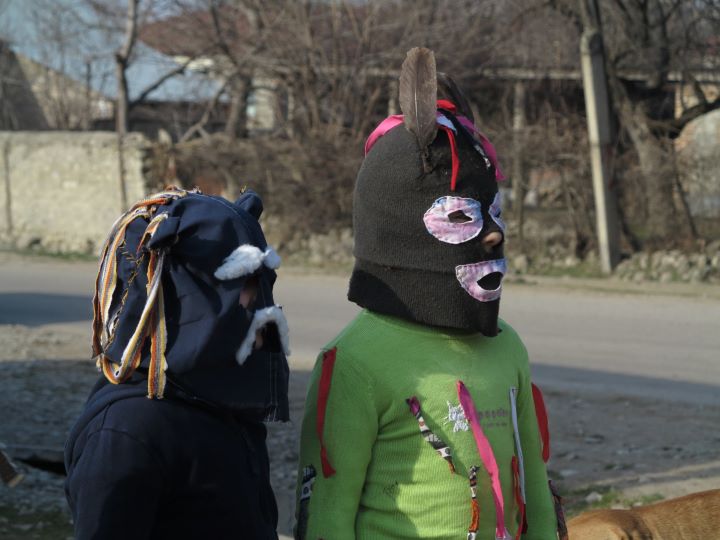 dwoje dzieci stoi na ulicy w maskach na głowach