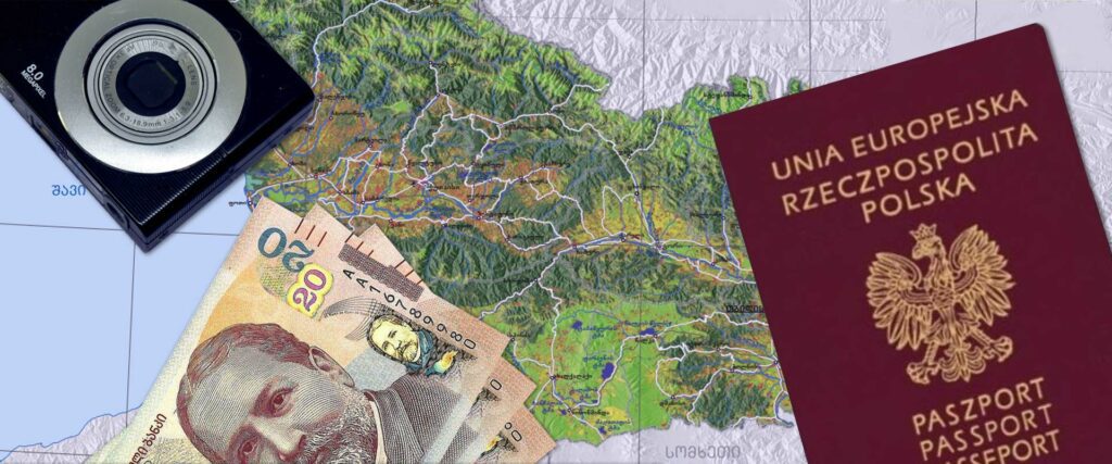 Paszport polski, banknoty gruzińskie i aparat fotograficzny na mapie Gruzji